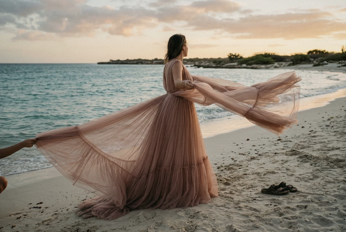 A woman in a long flowing gown with the train caught by the wind on the sand at Arashi Beach, the classic flying dress Aruba photograph
